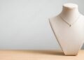 Elegant necklace displayed on a stylish jewelry bust against a neutral backdrop.
