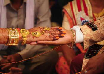 man in white dress shirt holding gold and red crown