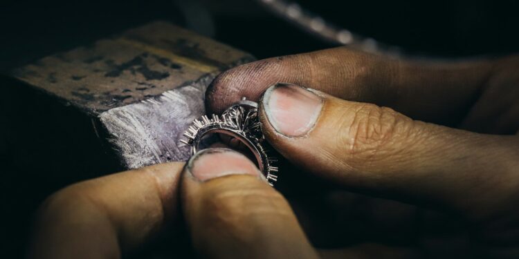 Person working on a piece of jewelry in light